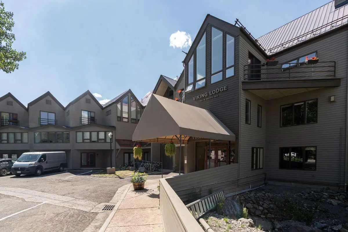 The entrance to Viking Lodge, complete with a welcoming awning, prominent signage, and bicycles parked nearby. Large windows allow glimpses inside, hinting at the amenities within the building and providing a sense of arrival at a well-kept complex.